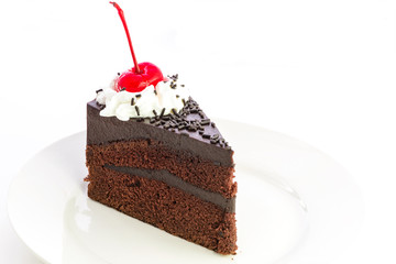 Isolated slice of chocolate cake  with  cherry and cream