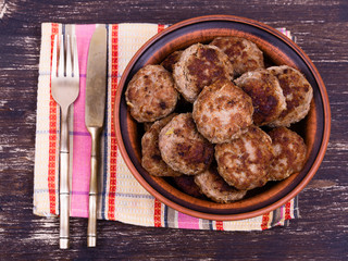 Fried cutlet in the plate on wooden table