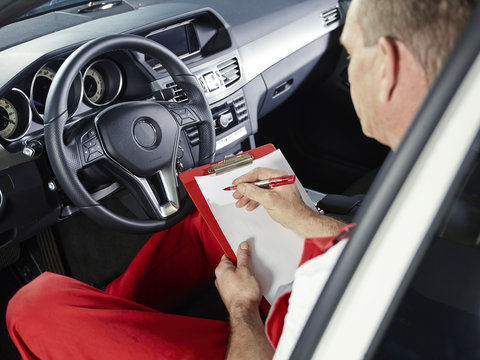 Car mechanic checks the milage of a car