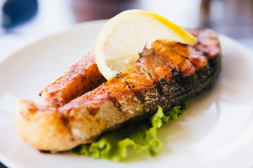 grilled salmon with lemon, asparagus on white plate