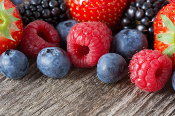 assorted fresh juicy berries on wooden background