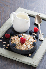 cereal, fresh berries and jug of milk