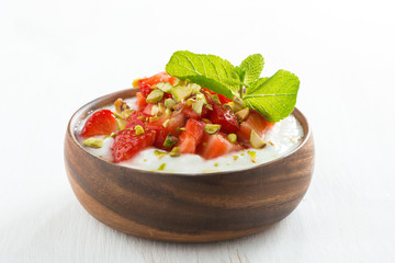 dessert of yogurt with fresh strawberries, pistachios and mint