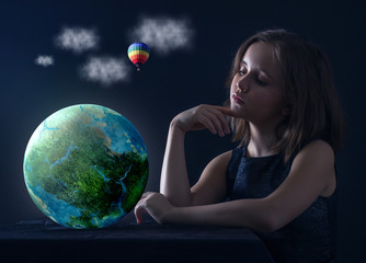 Teen girl with planet earth in his hands.