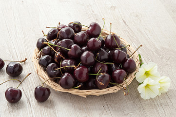 Cestino in vimini con ciliegie e fiori freschi