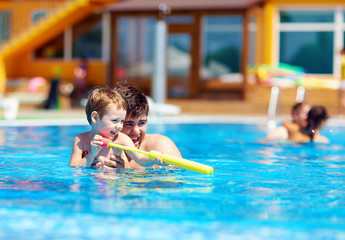 Naklejka premium father and son having fun in pool