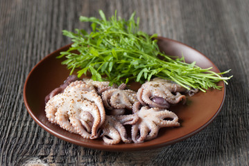 Octopus and green salad in a plate on the table