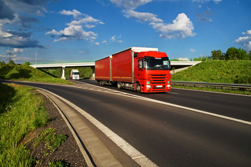 Fototapeta na wymiar Red truck driving down the highway