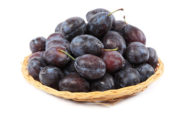 Fresh plums in a wooden basket.