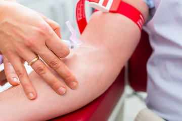 Ärztin bei Blutabnahme an Patient