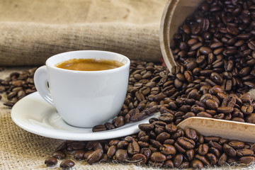 fresh espresso coffee in white cup  with roasted coffee beans