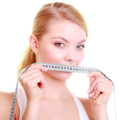 Fitness girl fit woman covering her mouth with measuring tape