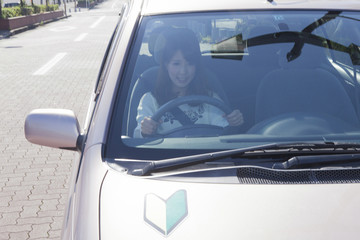 初心者マークを貼って運転する女性