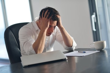 frustrated young business man working on laptop computer at home