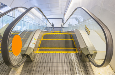 Empty escalator or moving stair. Also called stairway or staircase. Modern architecture design with step, glass for lift people up floor building i.e. shopping mall, airport, metro and subway station.