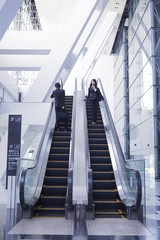 エスカレーターを昇降する男女