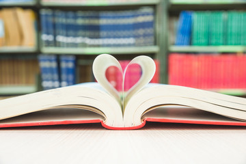 Heart shaped book pages with library background