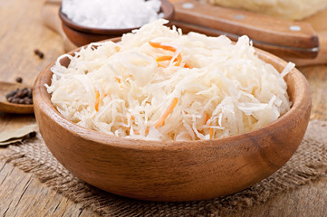 Sauerkraut with carrot in wooden bowl