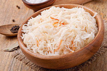 Sauerkraut with carrot in wooden bowl