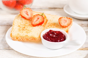 breakfast with fresh toasts, strawberries and strawberry jam