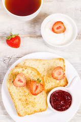 breakfast with fresh toasts, strawberries and strawberry jam