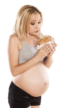 Pregnant women eagerly eating the sandwich