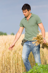 Naklejka na ściany i meble Happy farmer in wheat field