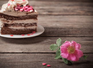 pink rose and cake on wooden background