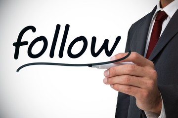 Obraz premium Businessman writing the word follow