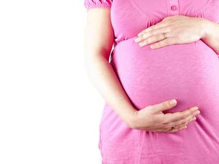 Pregnant young woman in pink holding her belly