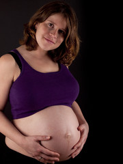 Pregnant young woman holding her naked belly