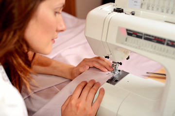 Young attractive woman sewing