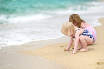 Naklejka premium Two little sisters having fun on a beach