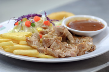 Grilled Pork steak with french fires ,salad ,bread ,sauce