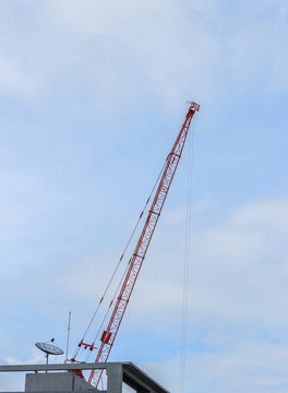 Red crane on blue sky background
