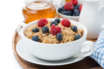 oat porridge with berries and honey, close-up, isolated
