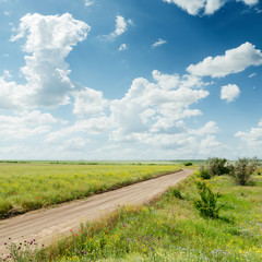 dirty road to horizon in blue cloudy sky