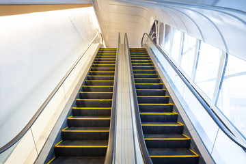 Empty escalator or moving stair. Also called stairway or staircase. Modern architecture design with step, glass for lift people up floor building i.e. shopping mall, airport, metro and subway station.