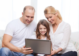 parents and little girl with laptop at home