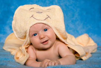 Smiling baby lying on a blue background