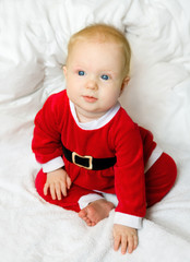 Baby girl dressed as Santa Claus