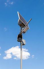 Traffic light and solar cell panel against blue sky