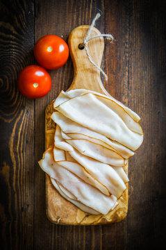 Sliced chicken breast on wooden background