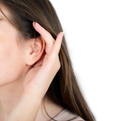 Woman holds her hand near ear and listens