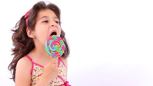 Little girl licking a lollipop, close up