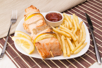 Salmon skewers with fries