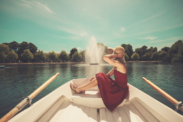 Woman relaxing in a rowing boat on lake