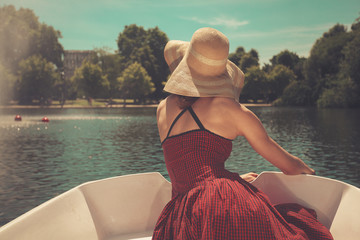 Woman in rowing boat looking at lake © LoloStock
