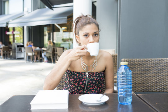Beautiful woman drinking coffee in the terrace restaurant.