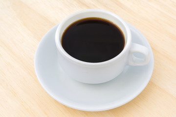 Black coffee in a white cup on wood.